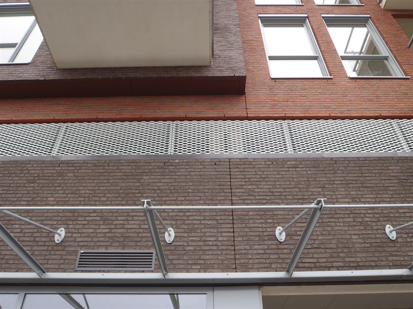 Detail van de MD Strekmetaal plint Appartementencomplex Portage in Zaltbommel, zorgt voor ventilatie en daglicht rondom het garagedek